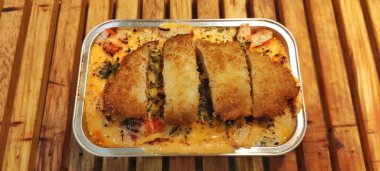 Alüminyum folyo konteynırında servis edilen Japon pirinçli Mentai soslu çıtır tavuk Katsu. Mutfak işi konsepti. Yemek Fotoğrafçılığı Sunumu