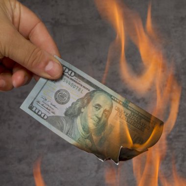 Gri arkaplanda dolar ve banknot yakma