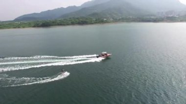 Mutlu yakışıklı adam wakesurfing bir denizde ve bir tekne ile çekti.
