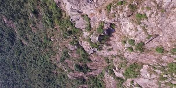 Jeunes randonneurs au sommet d'une montagne assis sur la falaise escarpée profitant d'une vue sur la vallée 