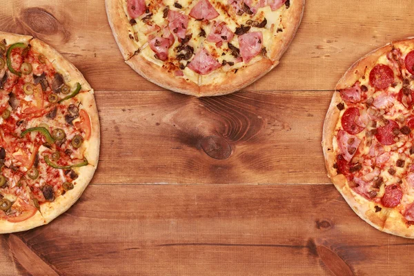 Três pizzas saborosas na mesa — Fotografia de Stock