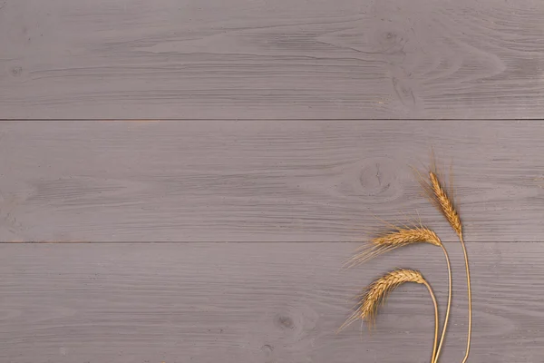 Oreja de trigo sobre mesa de madera — Foto de Stock