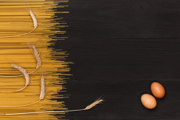 Pasta for cooking, egg on wooden table — Stock Photo, Image