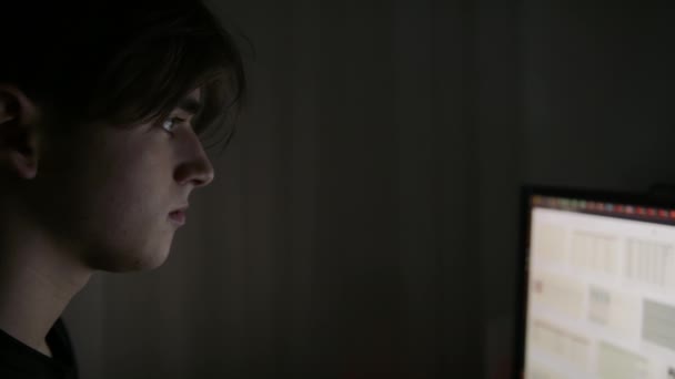 Nachtaufnahme eines Teenagers in der Nähe des PC, er druckt den Text zum Fernstudium aus