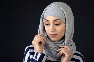 Stüdyo portre güzel bir genç kadının başında, karanlık bir arka plan üzerinde olağandışı bir Fularlı Ortadoğu türü