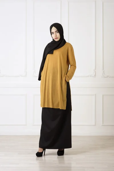 Studiofoto einer schönen jungen Frau östlichen Typs in voller Länge, auf hellem Hintergrund, im muslimischen Stil gekleidet — Stockfoto