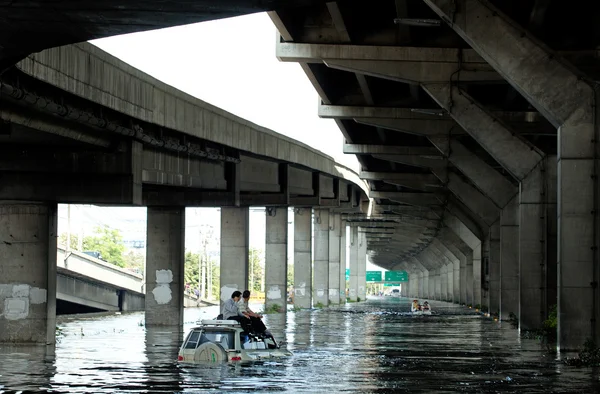 Editorial photos flooding in Bangkok, two men sitting on the roof of the car to escape from the water, photographed in 2011 — Stock Photo, Image