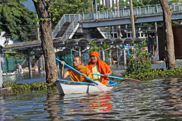 Editorial photo of two Buddhist monks floating in a boat on a flooded street in Bangkok in 2011 — Stock Photo, Image