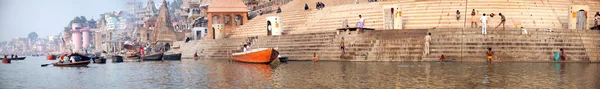 Editoryal fotoğraf, Varanasi waterfront şehir, binalar, ghats, turist tekneleri ve yerel halkın günlük işlerine dahil ile büyük bir Panoraması — Stok fotoğraf