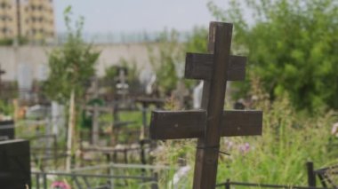 Kasvetli Hristiyan mezarlığı. İnsanların gömüldüğü yer. Ortodoks Rus mezarlığı. Eski ahşap haçın yeşil ağaçlara yakın görüntüsü bulanık arkaplan. Bulutlu bir gün. Uzayı kopyala Sessiz ve yalnız bir yer..