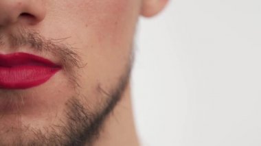 Bekar bir adamın dudaklarına yakından bakınca dudaklarına kırmızı ruj sürersin. Ciddi moda Kafkas metroseksüel ya da siyah sakallı eşcinsel çocuk, beyaz arka planda sakallı bıyıklı gülücükler. Boşluğu kopyala.