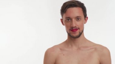 Güzel, genç, efemine, travesti, yarı çıplak, sakallı, gülümseyen, kalbi olan, elleri beyaz arka planda olan bir adam. Sevgililer Günü 'nün romantik konsepti. Uzayı kopyala Ön görünüm