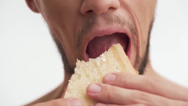 수염을 수염을 기르고 수염을 덥수룩하게 늘어진 배경에 맛있는 샌드위치를 탐욕스럽게 — 비디오