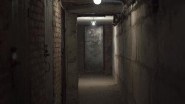 Terk edilmiş pis korku koridoru. Karanlık. Bir lamba loş bir şekilde parlıyor. Hiç kimse. Boş yeraltı yolu, metal kapıları olan gizli bir yer. Gri beton ve tuğla duvarlar.