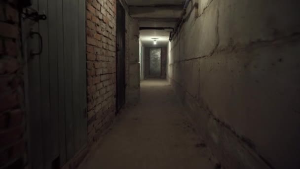 空旷可怕的黑暗长廊 地下室用混凝土 砖墙用关闭的门 天花板上有一个电灯泡放大放大 旧厂的黑色炸弹掩蔽所 室内景观 — 图库视频影像