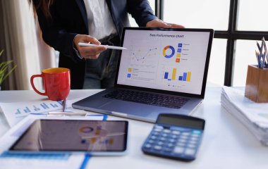 İşadamı bilgisayarla çalışıyor ve grafiği analiz ediyor