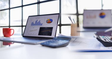 Ofiste dizüstü bilgisayar ve finansal çizelgeler var. iş konsepti.