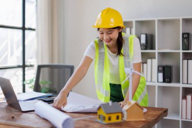 Ofiste tablet ve planla çalışan kadın mühendis veya mühendis.