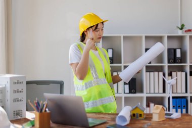 Kadın Asyalı mühendis ofiste çalışıyor.