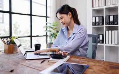 İşte dizüstü bilgisayar kullanan genç bir kadın.