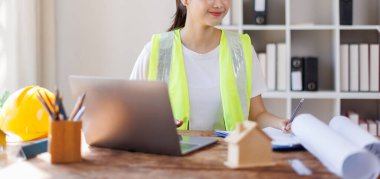 Dizüstü bilgisayar üzerinde çalışan mühendis kadın mühendis ve ofis planları, mühendislik ve inşaat konsepti.