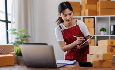 İşyeri sahibi dijital tablet kullanarak çevrimiçi dükkandaki müşterilere sipariş vermeye hazırlanıyor..