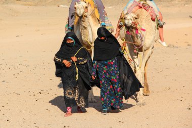 Hurghada, Mısır - 24 Nisan 2015: Yaşlı ve genç kadın-cameleers Sahra Çölü üzerinde 24 Nisan 2015 Hurghada develerini Mısır, ile Bedevi köyden