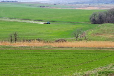 Çalışan bir traktörle ilkbahar yeşil alanı