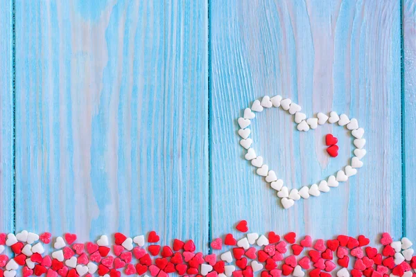 Red candy heart laying on white painted rustic wooden background — Stock Photo, Image