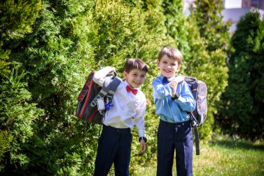 Mutlu çocuklar okula geri döner. İlkokul öğrencisi dışarıda sırt çantasıyla ders çalışmaya gitti. Çocuklar el ele gider. Dersler başlıyor. Sonbaharın ilk günü. İlkokuldan çocuk ve kardeşi..