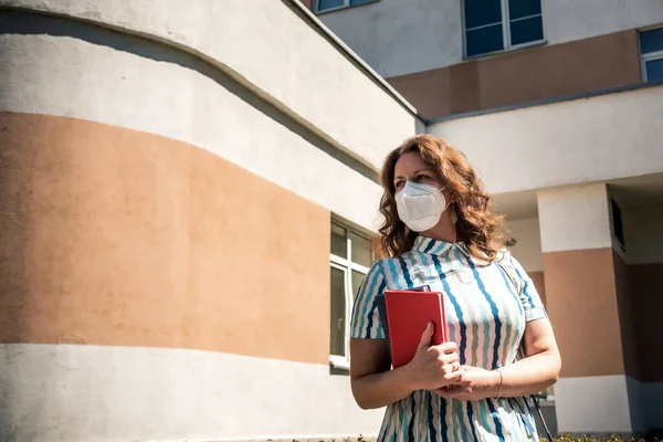 Teacher wearing a medicine healthcare mask outside school, wait for children, New normal lifestyle during coronavirus or Covid-19 crisis.