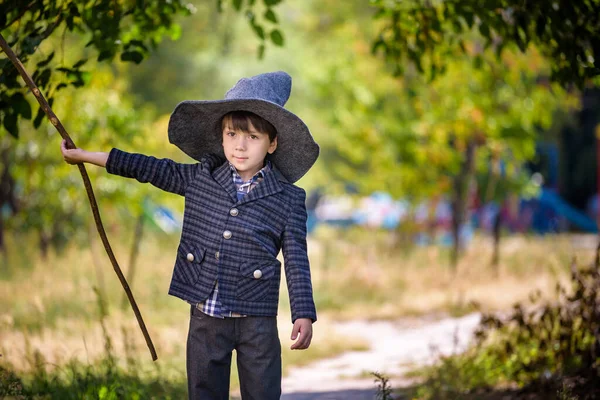 小男孩戴着尖尖的帽子 在户外玩魔杖 小魔法师万圣节的概念 — 图库照片