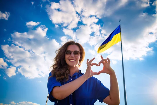 Молодая Веселая Женщина Держащаяся Руки Форме Сердца Фоне Украинского Флага — стоковое фото
