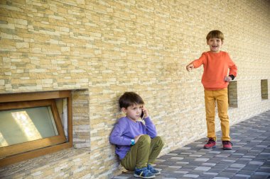 Ağlayan küçük çocuğun portresi, arka planda onu işaret eden zalim çocuklarla yüzünü gizlemek, zorbalık yapmak ve onu aramak. Genç çocuk yardım istemek için arıyor..