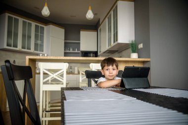 Bebecik tablete bakıyor. Eğitim, cihaz, bağımlılık, teknoloji, bağımlılık çocuk görme yetisi kavramı.