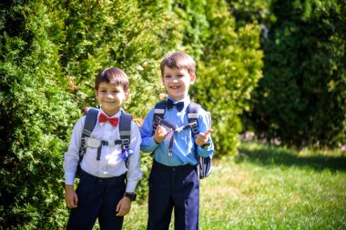 Mutlu çocuklar okula geri döner. İlkokul öğrencisi dışarıda sırt çantasıyla ders çalışmaya gitti. Çocuklar el ele gider. Dersler başlıyor. Sonbaharın ilk günü. İlkokuldan çocuk ve kardeşi..