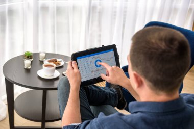 Adam pahalı bir otel odasında bir fincan kahve içerken dijital para ticareti yapıyor..