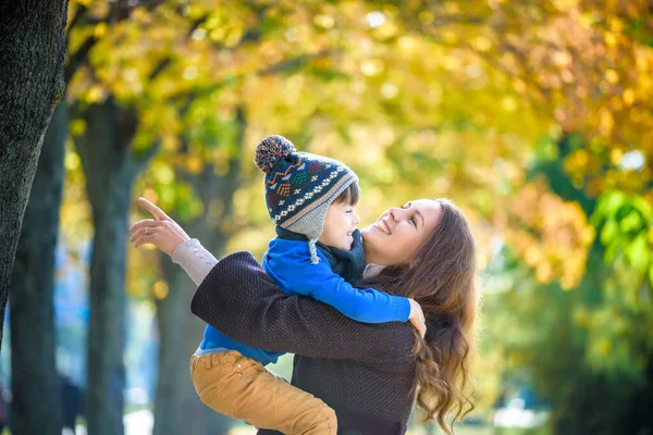 Χαριτωμένο Χαρούμενο Αγόρι Χαμογελάει Και Αγκαλιάζεται Μαμά Του Ανάμεσα Κίτρινα — Φωτογραφία Αρχείου