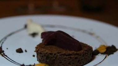 Sıcak çikolatalı tatlı konseptiyle serpiştirilmiş beyaz arka plandaki bir tabakta taze yapılmış çikolatalı kek. Yüksek kalite 4k görüntü