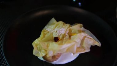 kavrulmuş armut esmer şekerle kaplanmış, beyaz bir tabakta servis ediliyor. Tatlı, içi yumuşak ve karamelli bir dış görünüş sunuyor. Doğal tatlılığı vurguluyor..