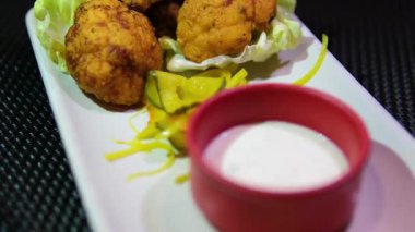 Üzerinde çırpılmış yumurta hamuru olan karnabahar parçalarıyla yakın çekim. Kızarmış karnabahar haşlanmış sebze yağı, yağ cızırtısı ve kabarcıklarla tavada kızartılır. Sağlıklı bitki yiyeceği.