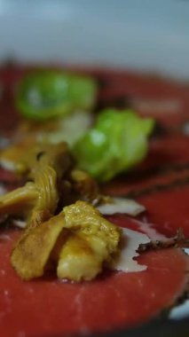 Parmesan ve chanterelles ile dekore edilmiş otantik italyan sığır eti carpaccio aperatif aperatifler zarif yemek yemekleri geleneksel leziz yemek tabakları servis eden zarif restoranlar.