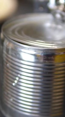 Evde mutfakta salata yapmak için konserve demir mısır konservesi açan demir bir mısır konservesi konservesini ahşap kesim tahtasının arka planında açın. Yüksek kalite 4k görüntü