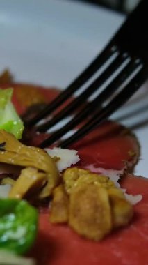 Parmesan dilimli çiğ sığır eti ve beyaz tabakta chanterelle mantarından yapılmış leziz bir carpaccio. Restoran tarzı İtalyan aperatifi. Güzel yemek gurmesi.