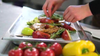 Elmalı ördek bacağı ev yapımı pişirme işlemi. Genç bir kadının elleri elmaları keser, tepside et düzenler, pişirir ve lezzetli köy yemeklerini servis etmeye hazır hale getirir..