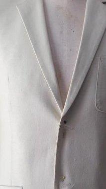 Beyaz ceketin alt kenarını kapatın, düğmelerini vurgulayın ve pürüzsüz bitirin. Yüksek kalite 4k görüntü