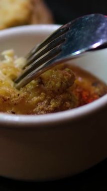 Los Angeles, Kaliforniya 'da çatalla kaplanmış kırmızı soslu tavuk toplama sahnesi. Bir restoranda çatal ve bıçakla yenen siyah bir tabakta kızarmış kanatlar.