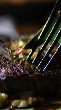 Yakından ve yukarıdan bakınca ızgara bifteğin çatal ve bıçakla dilimlendiği taze et, patates püresi ve taze salata. Lezzetli detaylarla yakalanmış mükemmel bir gurme yemeği..