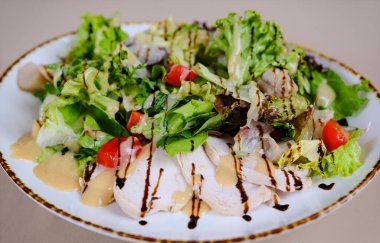 Green salad with baked chicken breast at white kitchen table. Healthy food, clean eating concept. Top view image. High quality photo