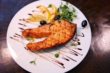 Grilled Salmon with lemon, olives and fresh thyme. Selective focus. High quality photo